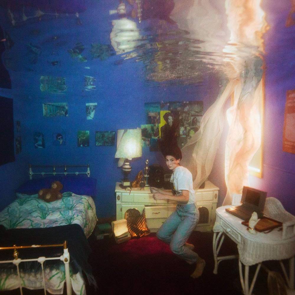 the album cover for Weyes Blood - Titanic Rising [RSD Essential Indie Colorway Rainbow Splatter LP]